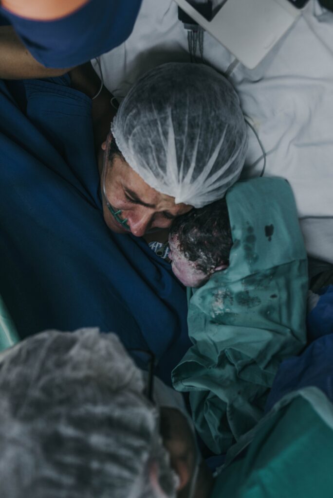 Mother first meets newborn in hospital, an intimate moment full of emotion.