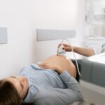 Pregnant woman receiving ultrasound scan in clinic setting.
