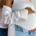 A close-up of a pregnant couple embracing, conveying love and anticipation.