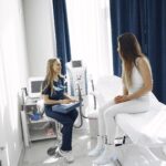 A healthcare professional consulting with a patient in a bright, modern clinic setting.