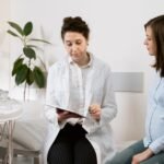 Doctor consulting pregnant woman with ultrasound machine in a medical clinic.