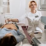 A pregnant woman receiving an ultrasound exam conducted by a healthcare professional in a medical clinic.