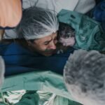 A powerful capture of a mother and her newborn in a hospital setting, showcasing raw emotion and the miracle of birth.
